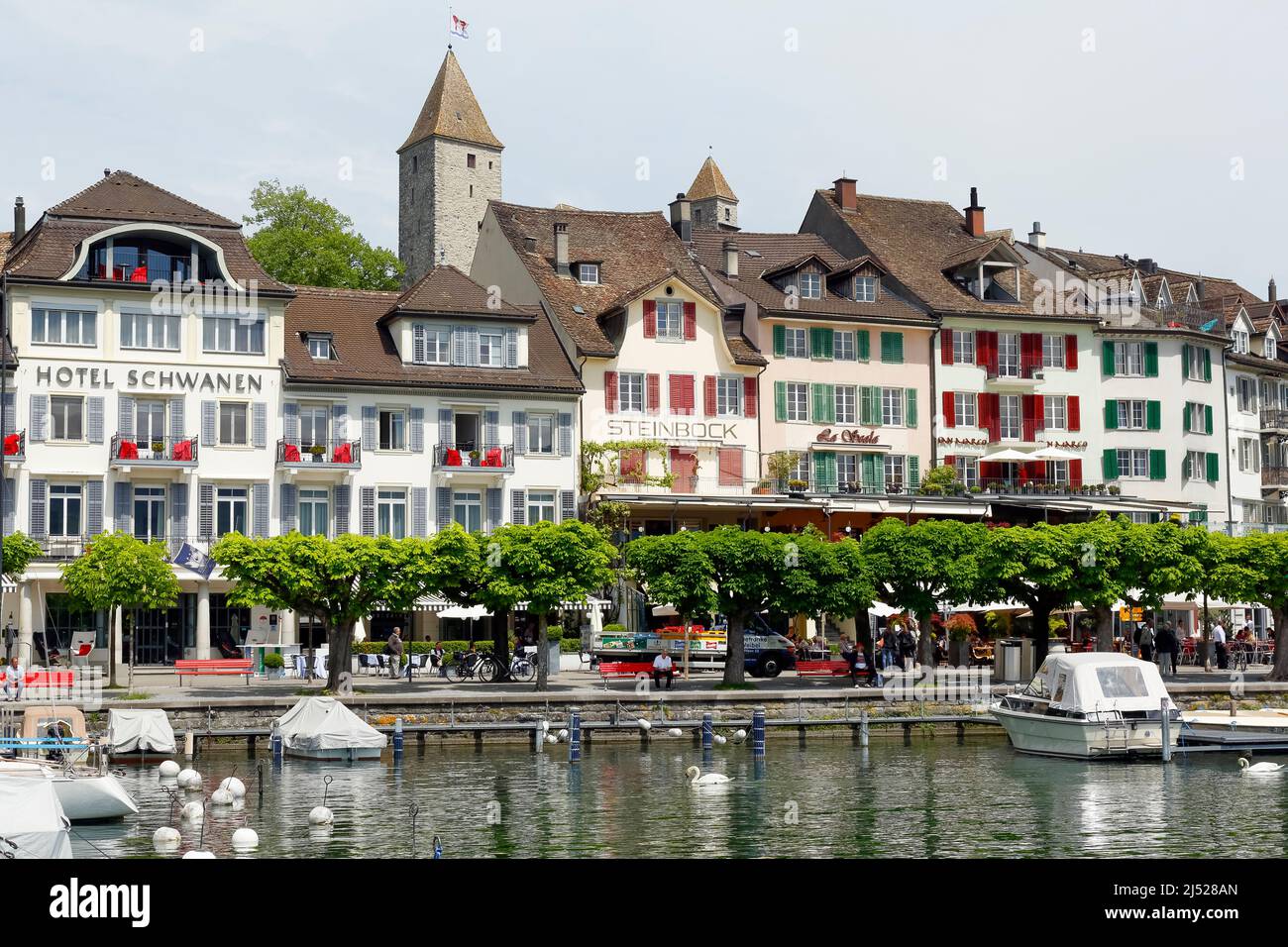 Rapperswil, Switzerland - May 10, 2016: Buildings, hotels and moored boats along promenade by the lakeside, all this shows the diversity of tourist at Stock Photo