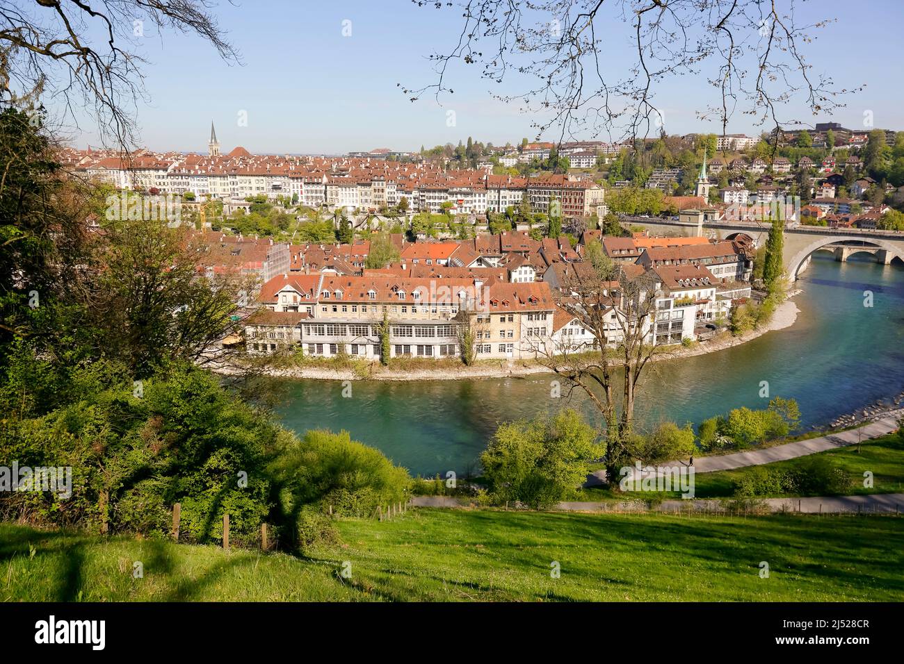 Bern, Switzerland - April 21, 2017: The buildings of the Old Town are visible in the distance behind the Aare river. There is a dense old town develop Stock Photo