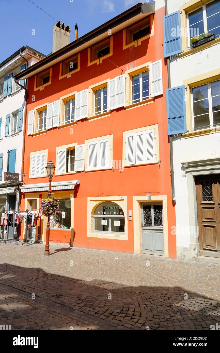 Yverdon-les-Bains, Switzerland - 18 April 2017: A colorful tenement house situated along the street in the old town, the windows are equipped with woo Stock Photo
