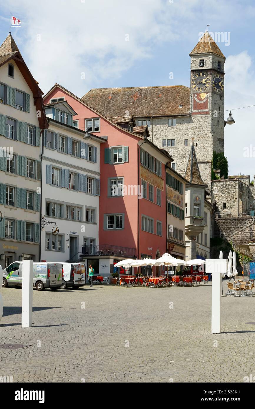 Rapperswil, Switzerland - May 10, 2016: The 13th-century castle with a clock tower towering over the city's buildings can be seen from the market squa Stock Photo