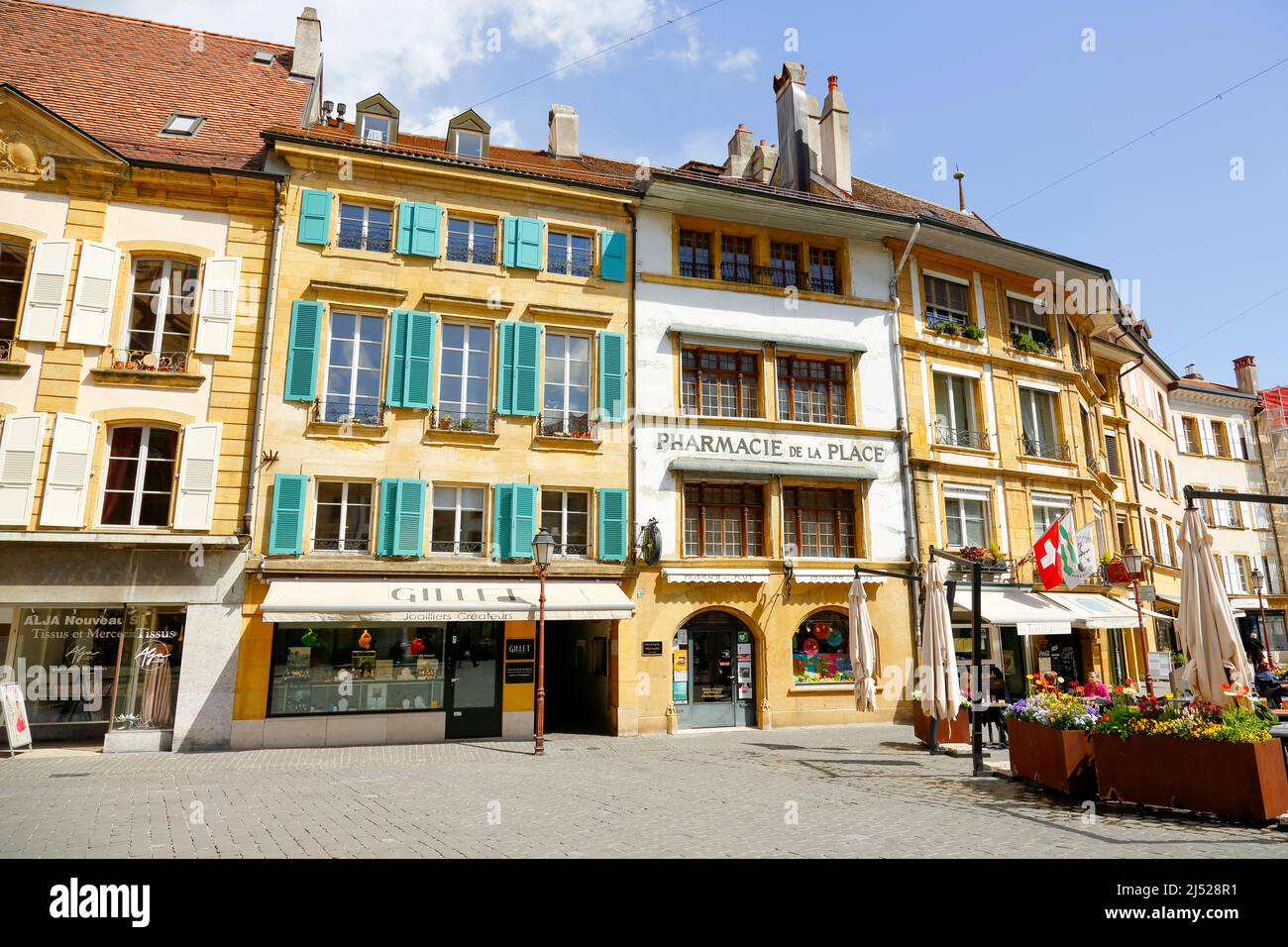 Yverdon-les-Bains, Switzerland - 18 April 2017: Various, colorful tenement houses along the frontage of the town square. There are several shop window Stock Photo