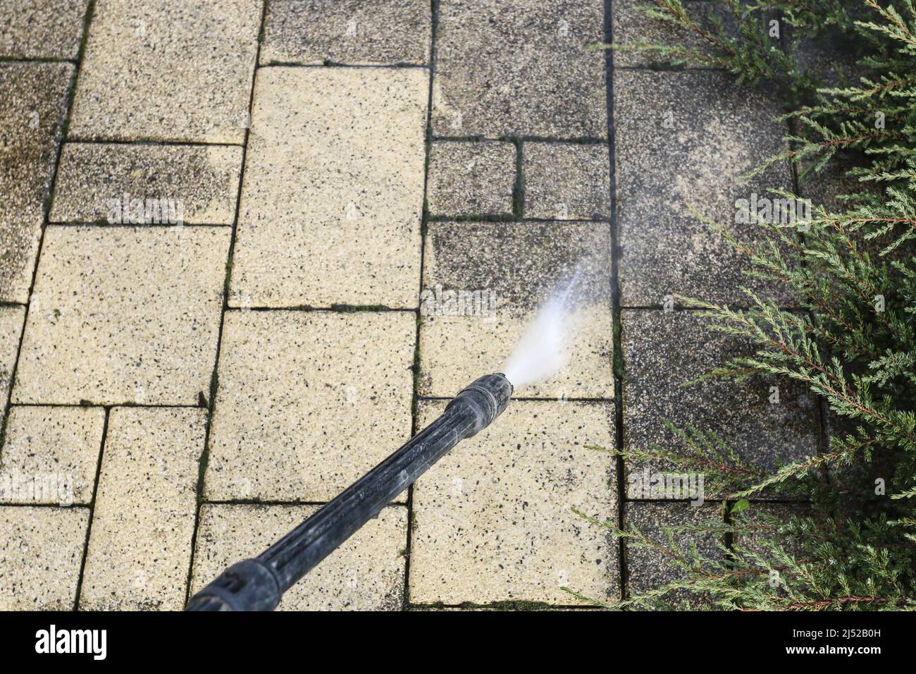 Cleaning dirty paving stones in the garden with a pressure washer. Home