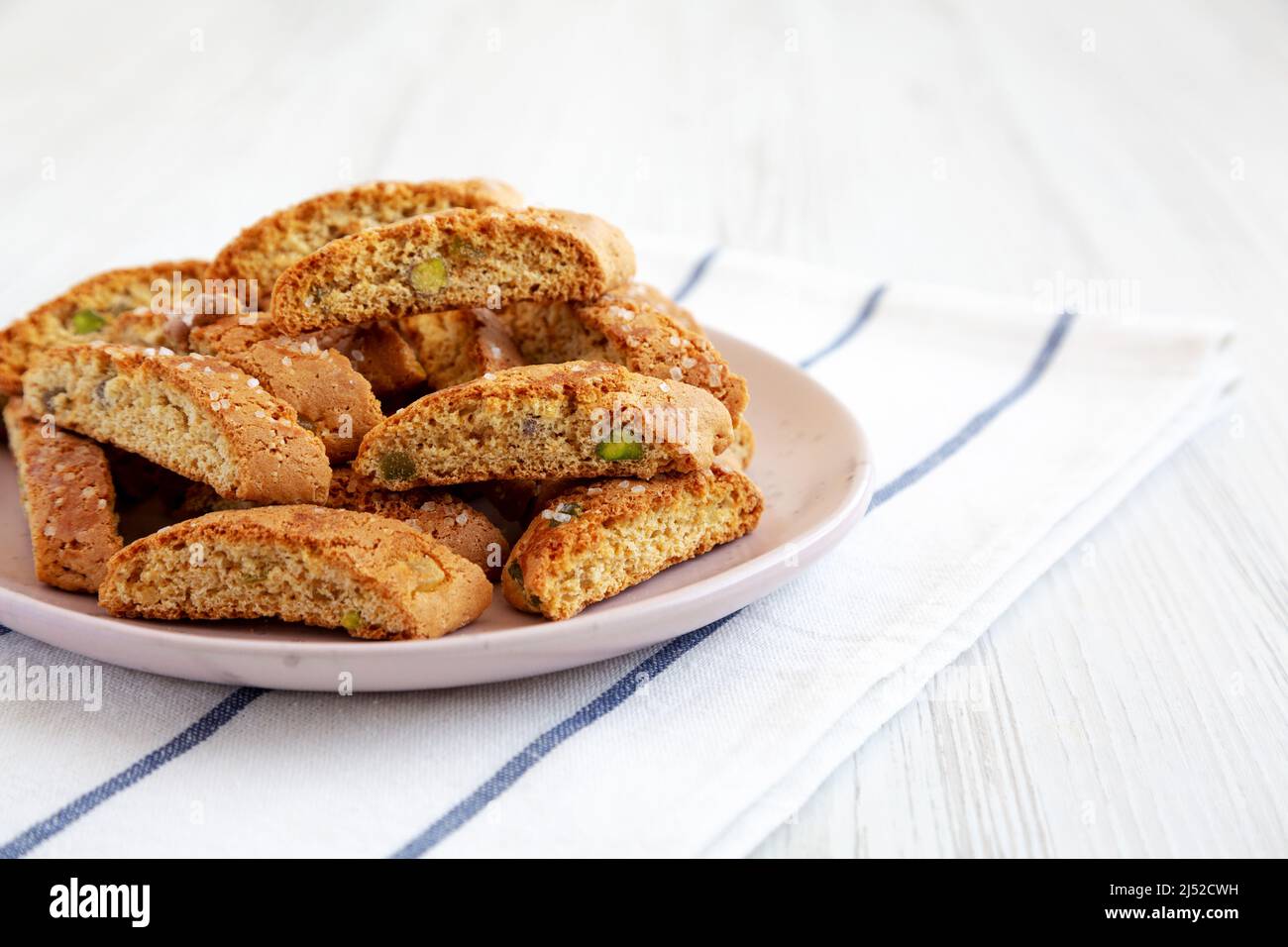 Homemade Italian Cantuccini with Pistachios and Citron on a Plate, side view. Crispy Pistachio and Citron Cookies. Copy space. Stock Photo