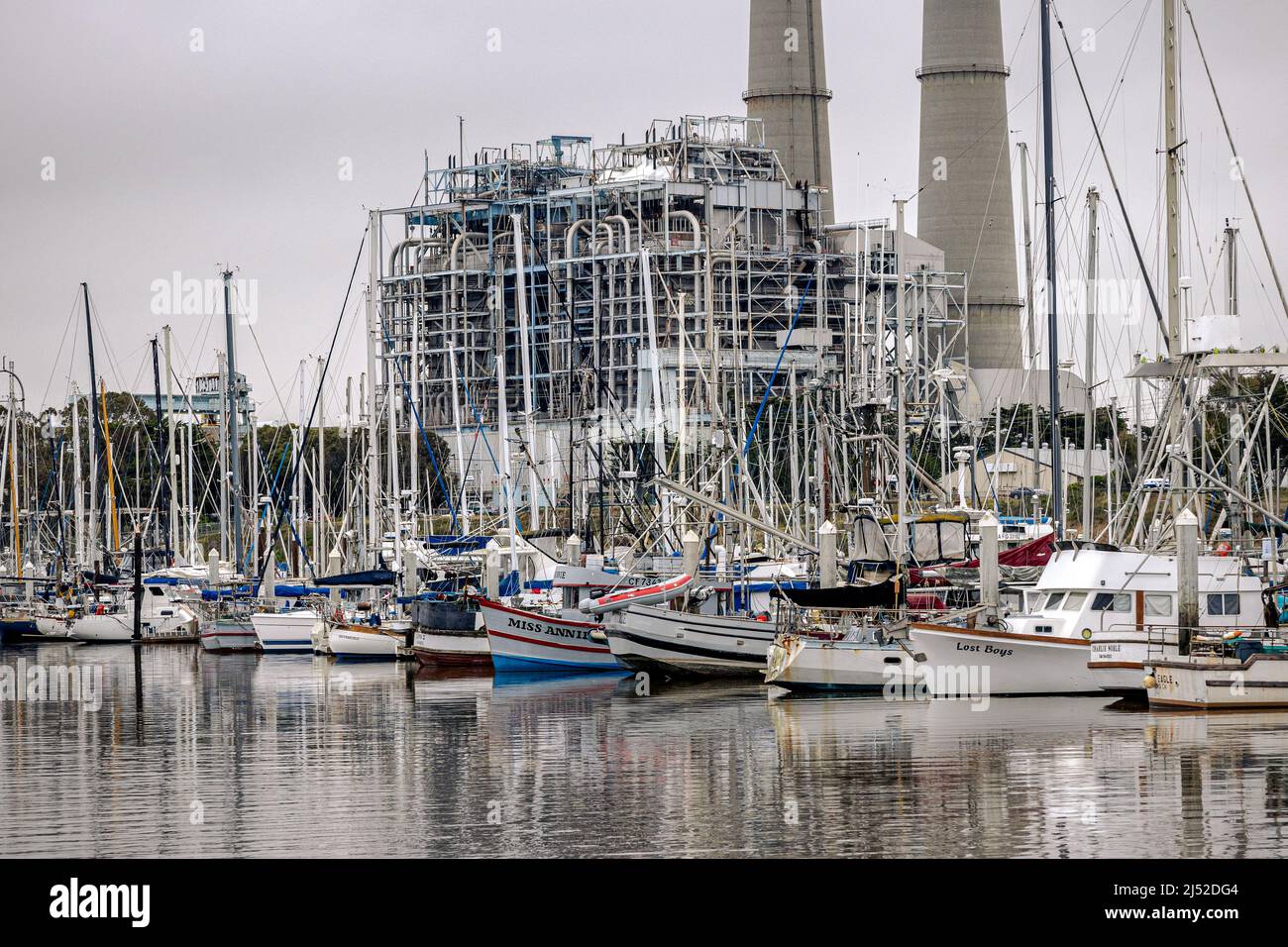 Boats docked at Moss Landing harbor CA with the power plant in the background Stock Photo
