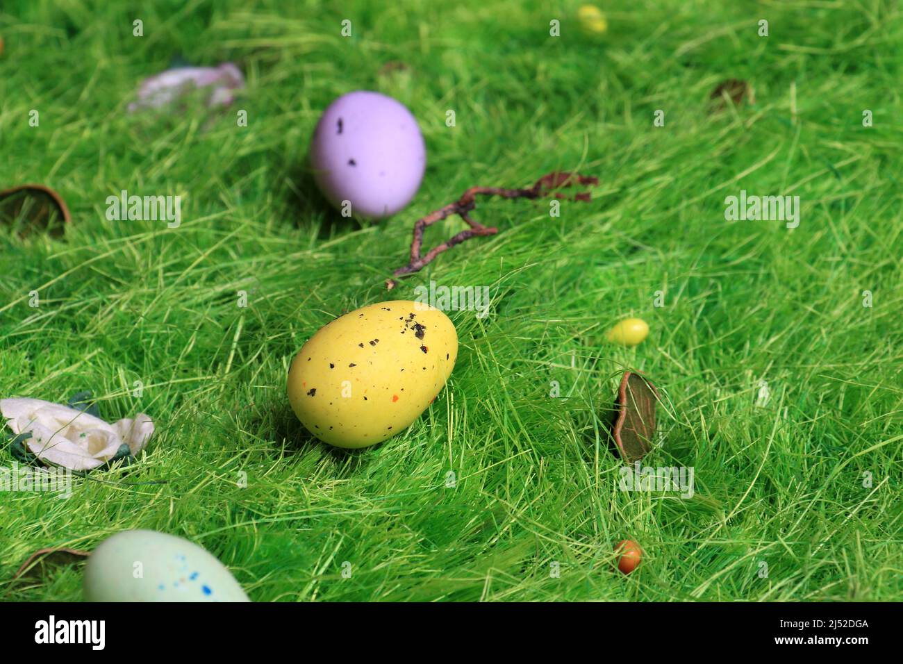 Pastel colored Easter chocolate eggs on green grass. Stock Photo