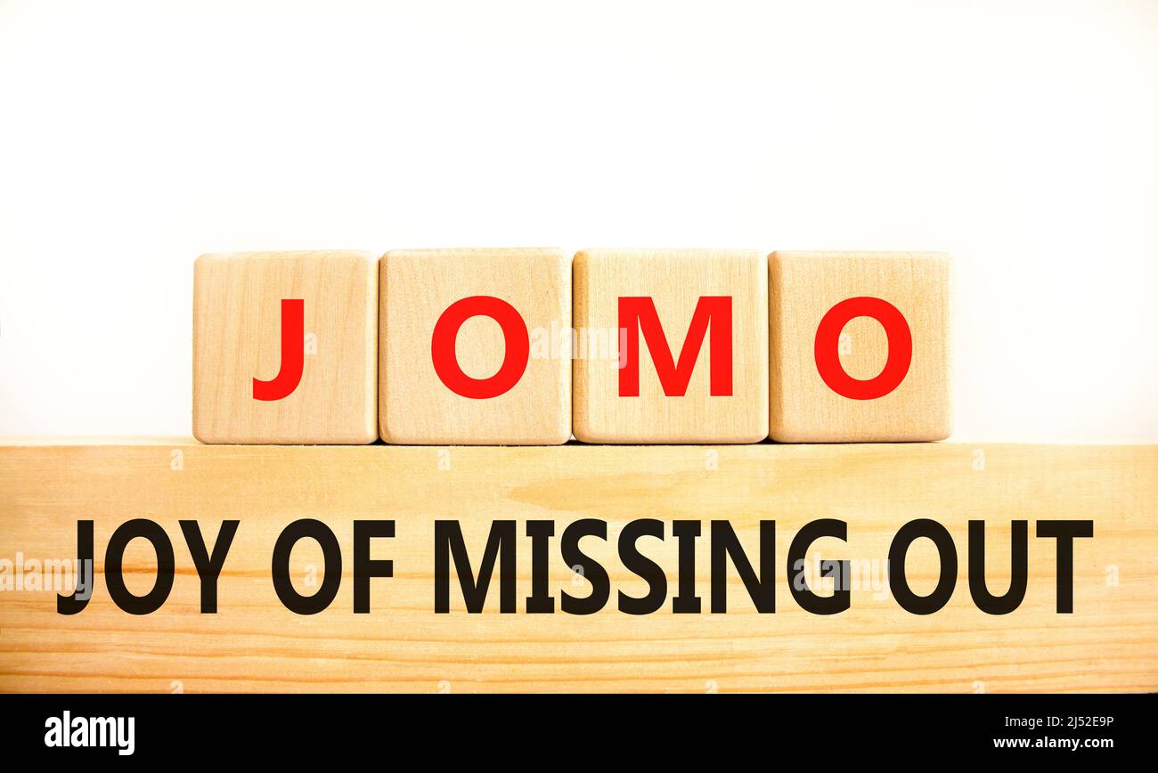 JOMO joy of missing out symbol. Concept words JOMO joy of missing out on wooden blocks on a beautiful white background. Business JOMO joy of missing o Stock Photo