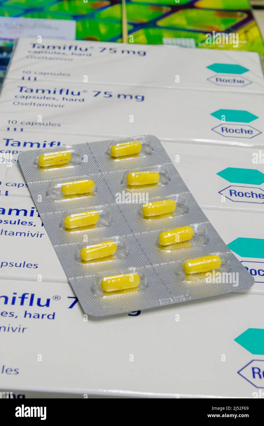 Blister pack of Tamiflu (Osteltamivir) capsules, 30mg, sitting on top of boxes of Tamiflu 75mg still in shrink wrapping, ready to be dispensed Stock Photo