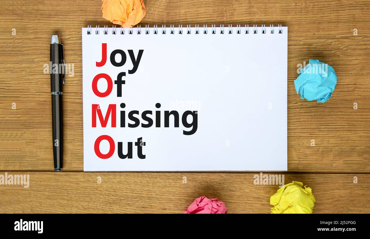 JOMO joy of missing out symbol. Concept words JOMO joy of missing out on the note on a beautiful white background. Business JOMO joy of missing out co Stock Photo