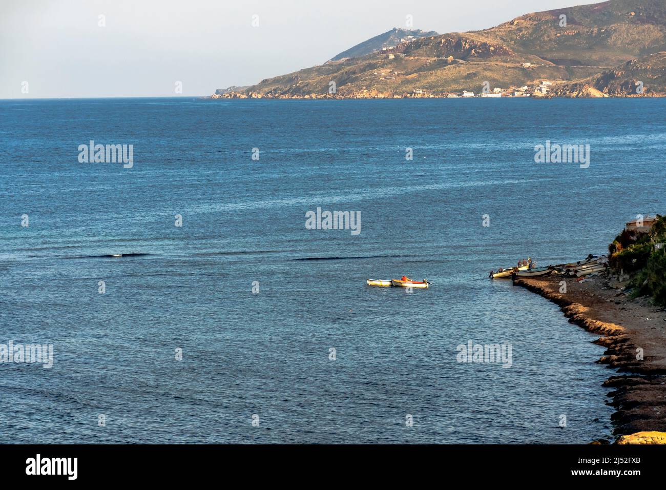Fishermen boats on blue mediterranean sea coast. Coastline mountain of Tizi Ouzzou . Algeria. Stock Photo