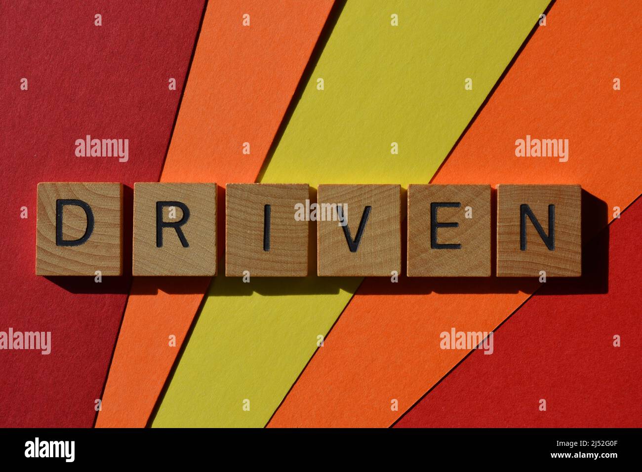 Driven, word in wooden alphabet letters isolated on multi coloured ...