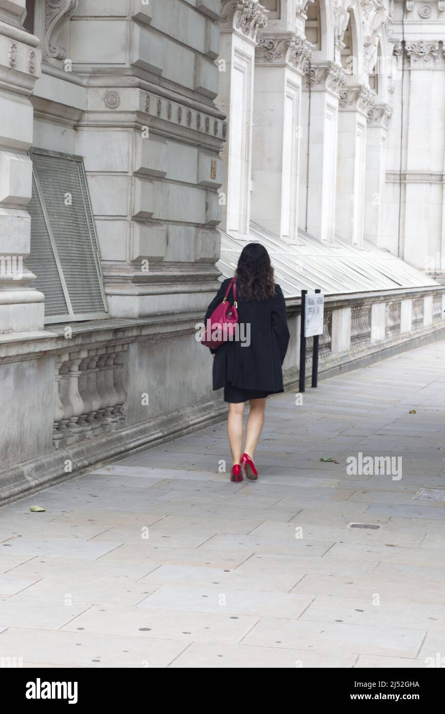 woman with a red handbag and walking in red shoes in London Stock Photo