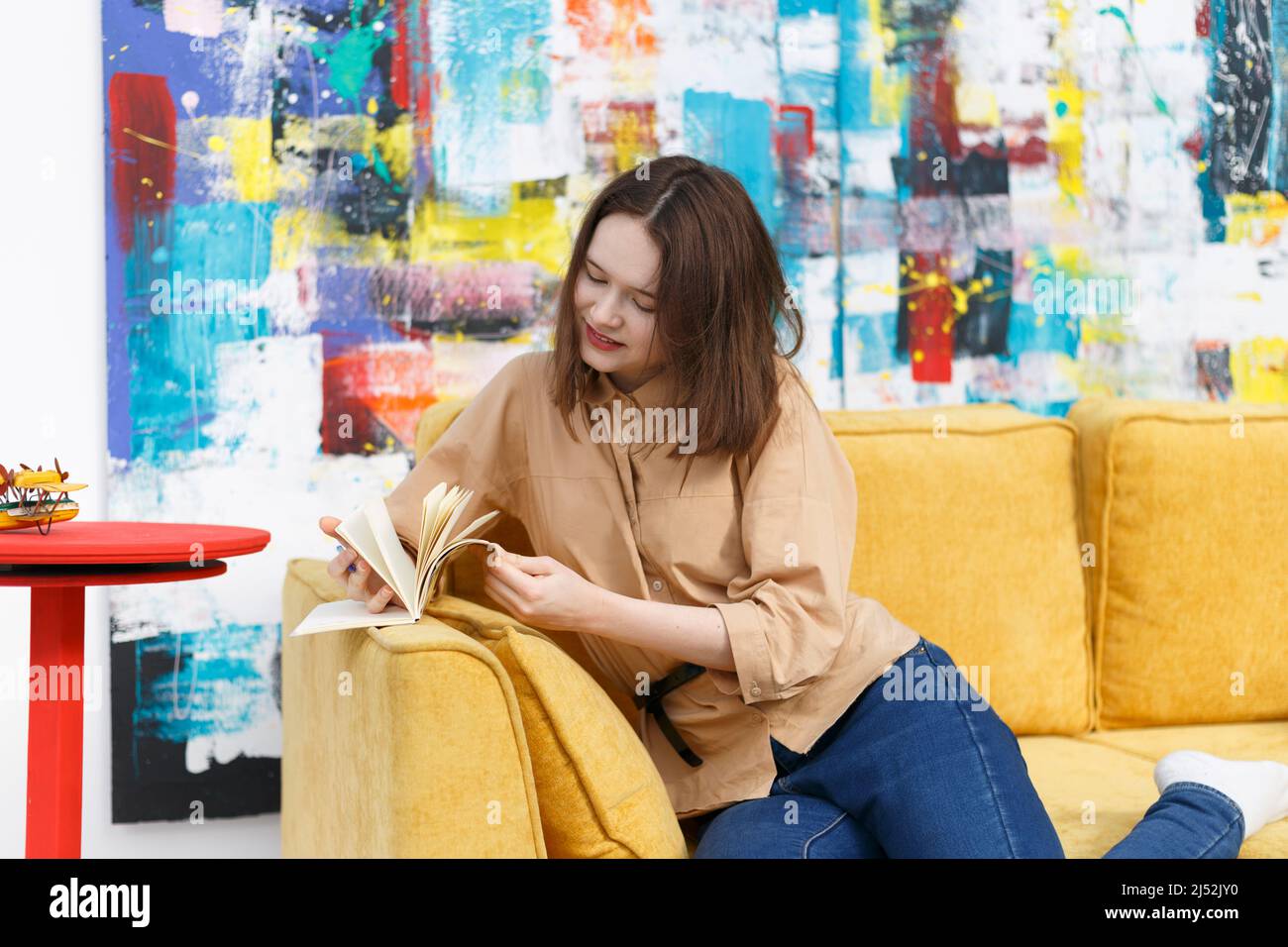 Smiling young woman turns the yellow notebook pages Stock Photo Alamy