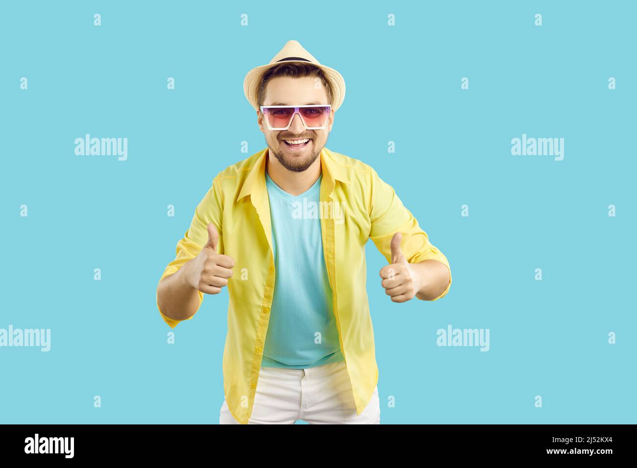 Happy man who is satisfied with his summer holiday smiling and showing thumbs up Stock Photo