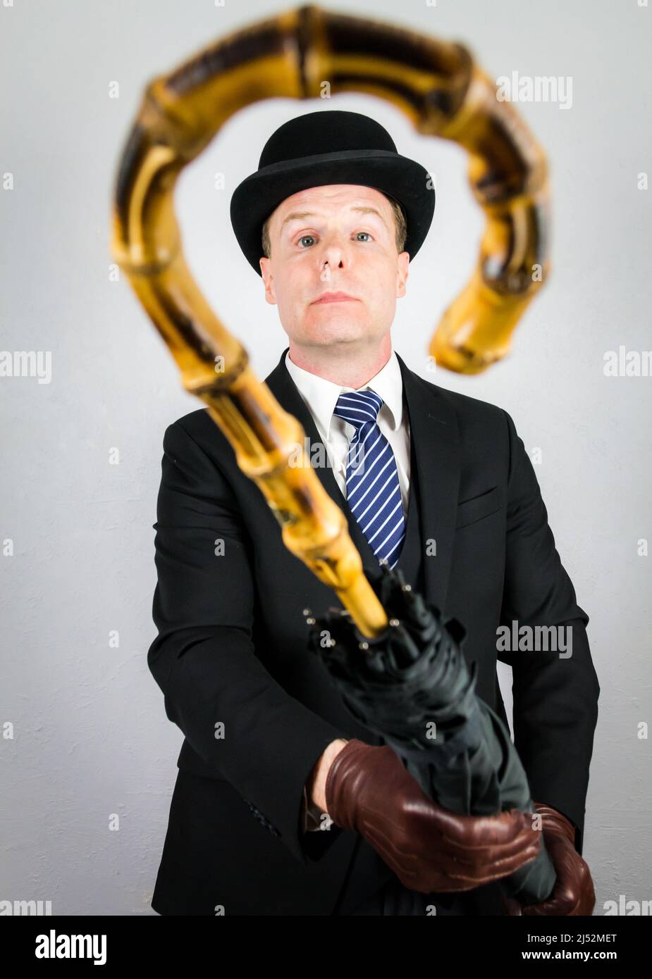 Portrait of British Butler in Dark Suit Offering Umbrella. Vintage ...