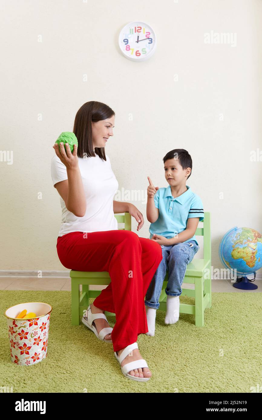 Teacher and preschool child are playing in playroom Stock Photo - Alamy