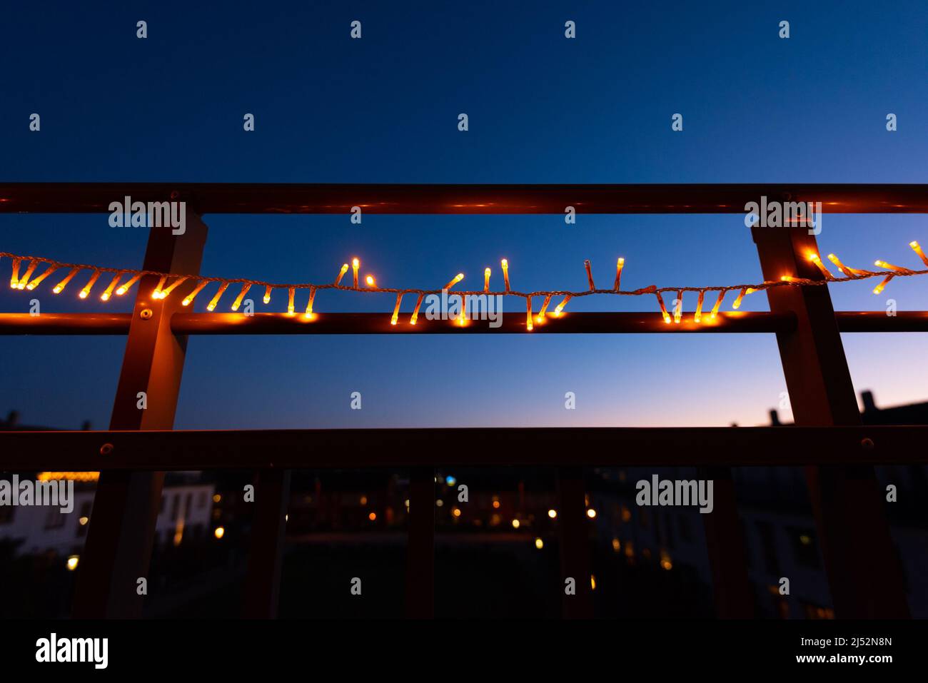 Christmas lights on the railings of a balcony at night Stock Photo Alamy