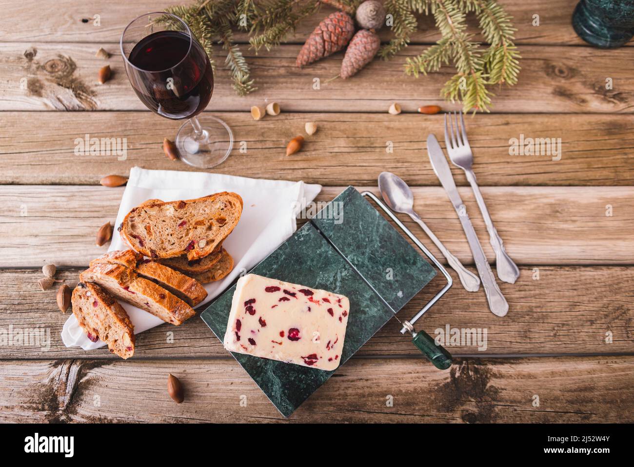 Delicious British Cheddar cheese with cranberry on a marble cheese cutting table. Stock Photo