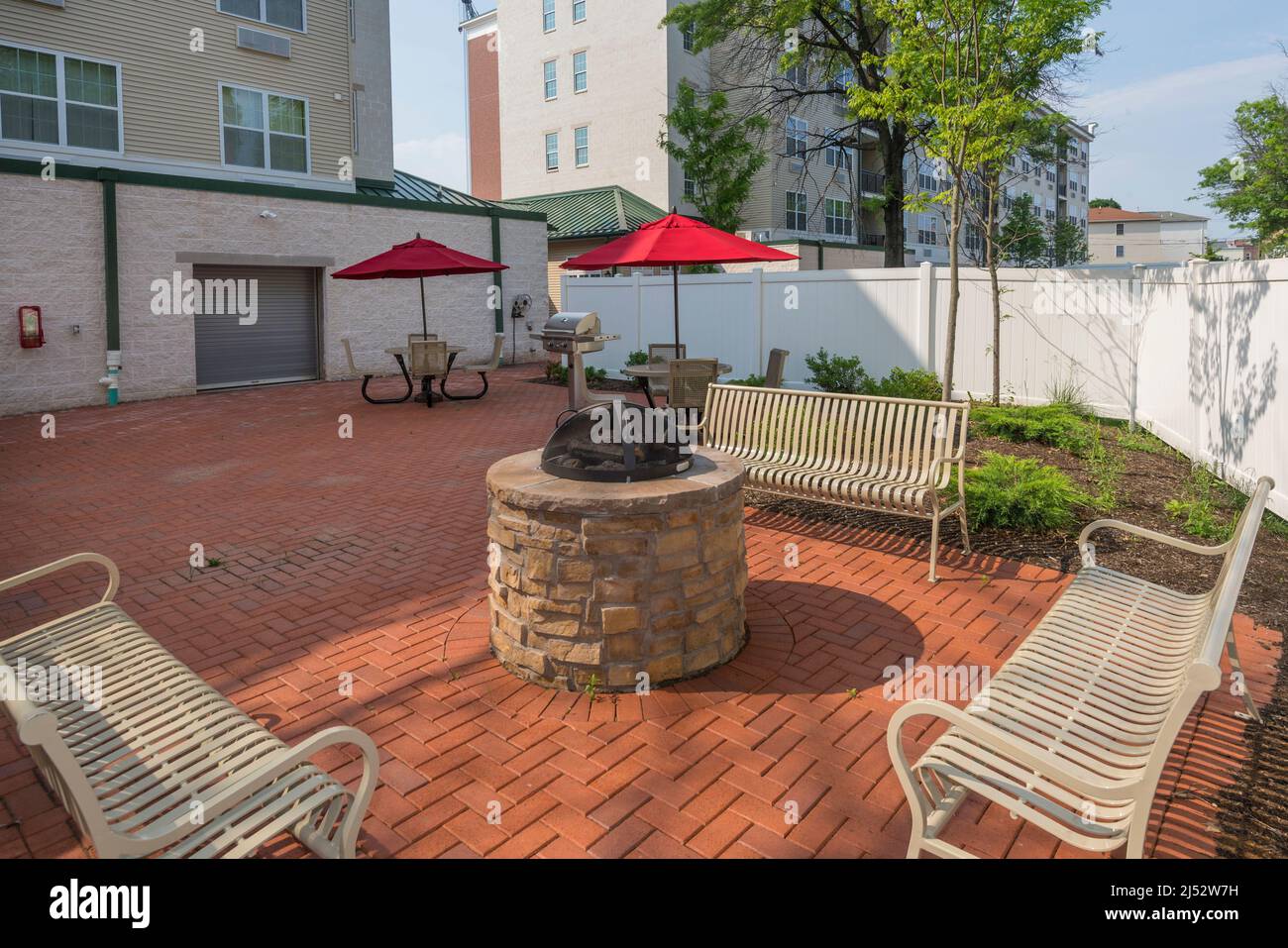 Benches and fire pit in apartment common area outside patio Stock Photo