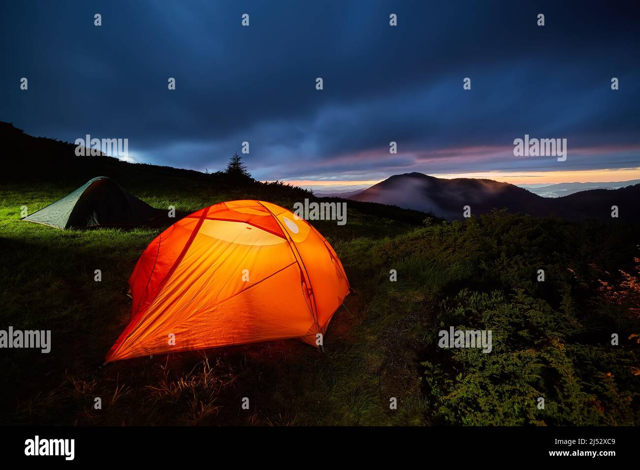 Illuminated orange camping tent under moon at night Stock Photo - Alamy