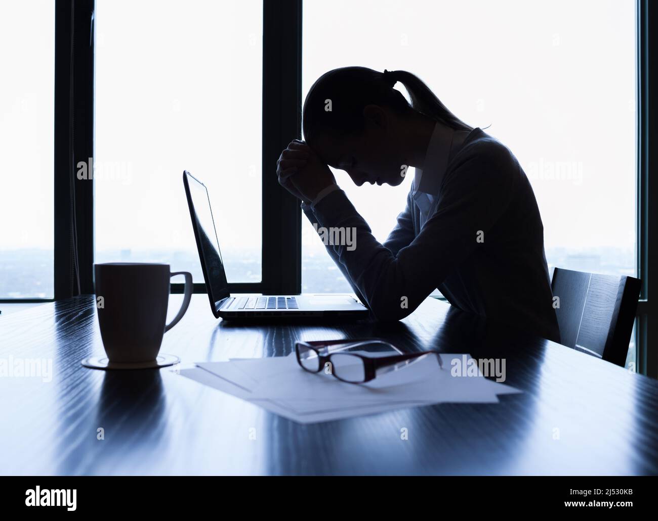 Tired and stressed business woman at her office desk. Pressure at work, prayer concept Stock Photo