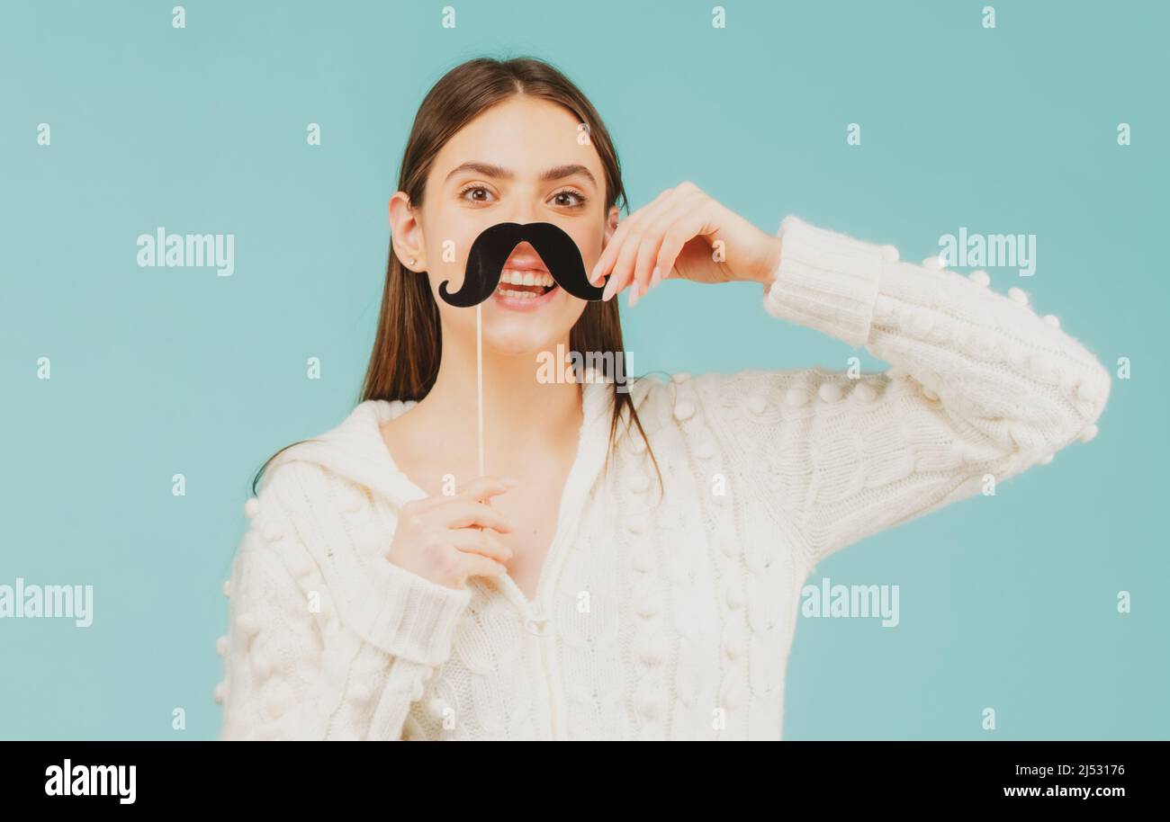 Photo booth party. Fake mustache on stick. Happy woman holding mustache and smiling. Stock Photo