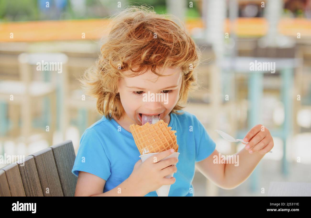 Cute child licking big icecream in waffles cone. Kids eating ice cream ...