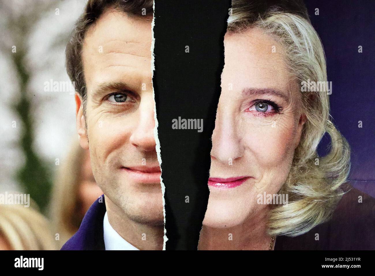 Torn campaign poster of the two candidates in the French presidential election Emmanuel Macron and Marine Le pen. Fractured France. 2022. Stock Photo