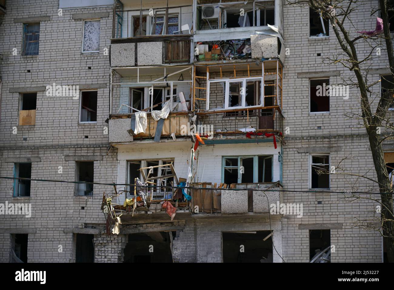 A destroyed residential building in the city that was damaged by a shell explosion during the war in Ukraine. House without windows. Stock Photo