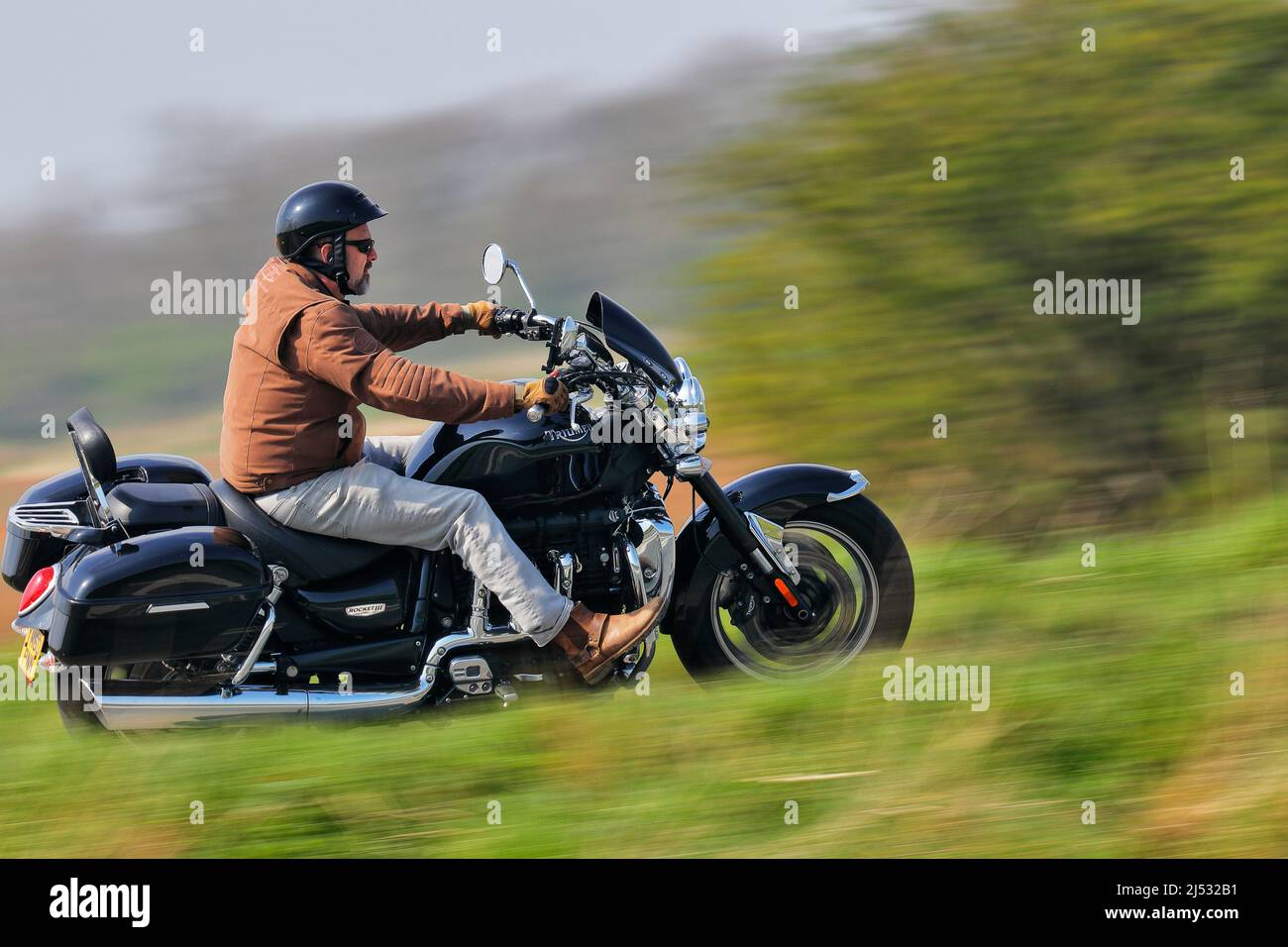 A motorcyclist riding a Triumph Rocket 3 motorcycle heading to Squires Bikers Cafe in Sherburn in Elmet,North Yorkshire,UK Stock Photo