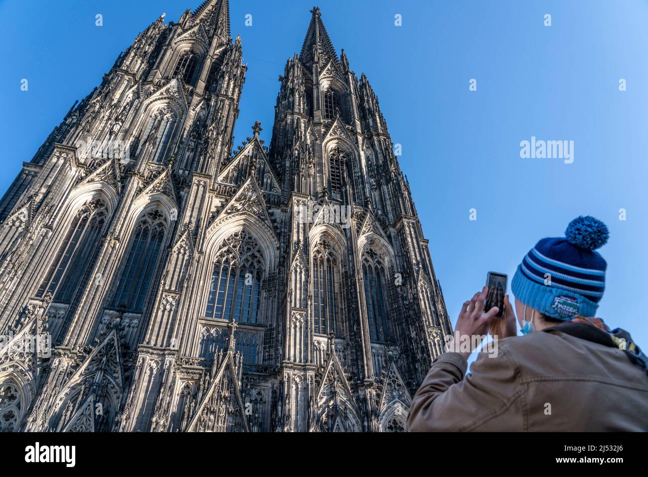 Cologne Cathedral, view of the west facade, at the north tower, tourist taking a photo with a mobile phone, Cologne, Germany, Stock Photo