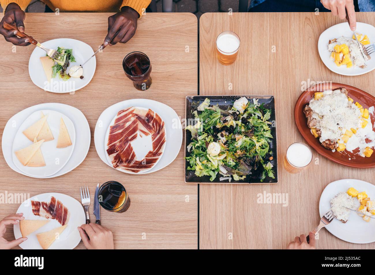 aerial view of a table with serrano ham, manchego cheese, salad and