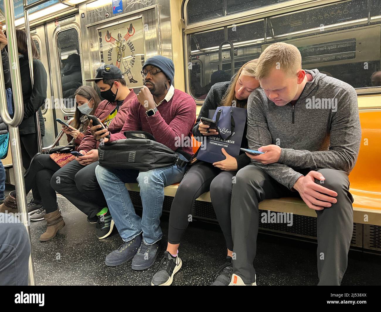 Subway Riders Glued To Their Phones As They Ride A New York City Subway