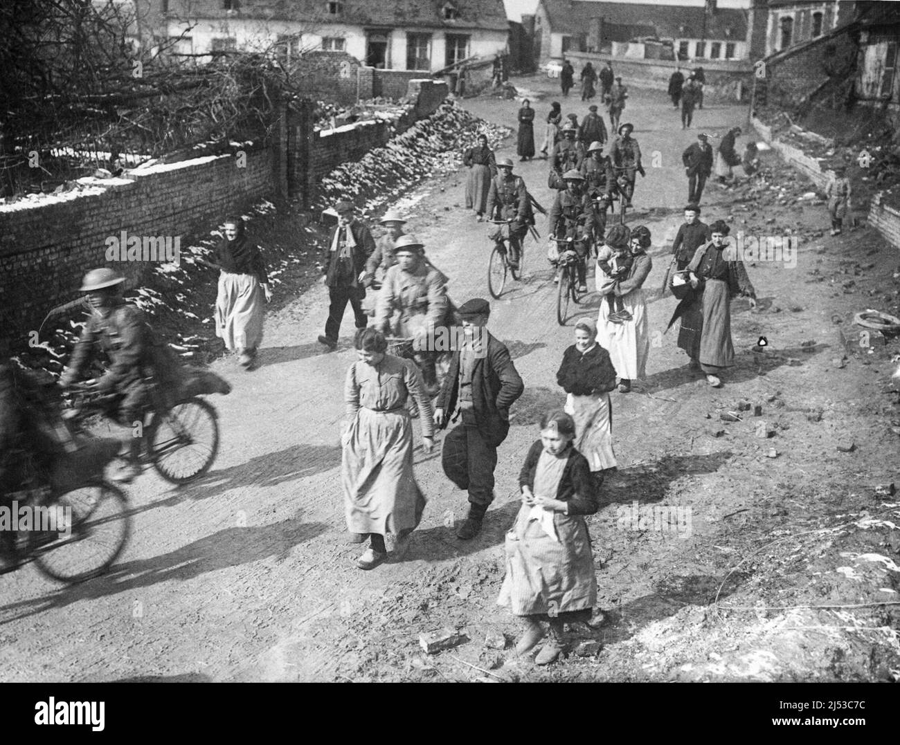 British soldiers arriving in a village in France. They are surrounded by women and children. Stock Photo