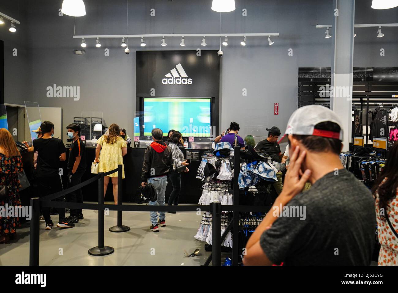 People seen shopping inside an Adidas store at The Outlets in Orange. Many  people shop at The Outlets in Orange, for clothes, shoes, watches, bags,  and backpacks with a discounted price. According