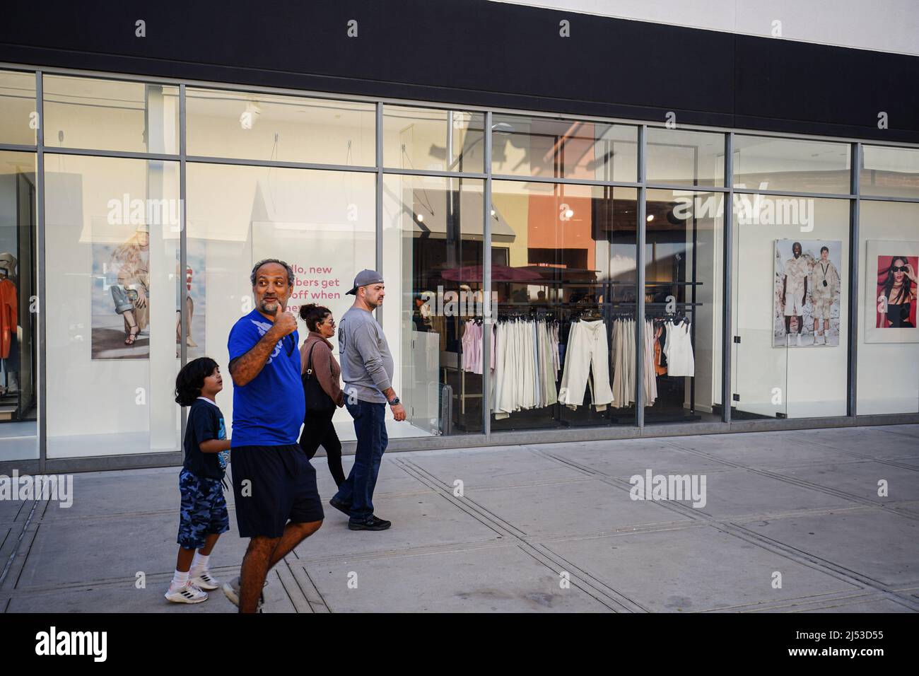 People seen walking past stores at The Outlets in Orange. Many people
