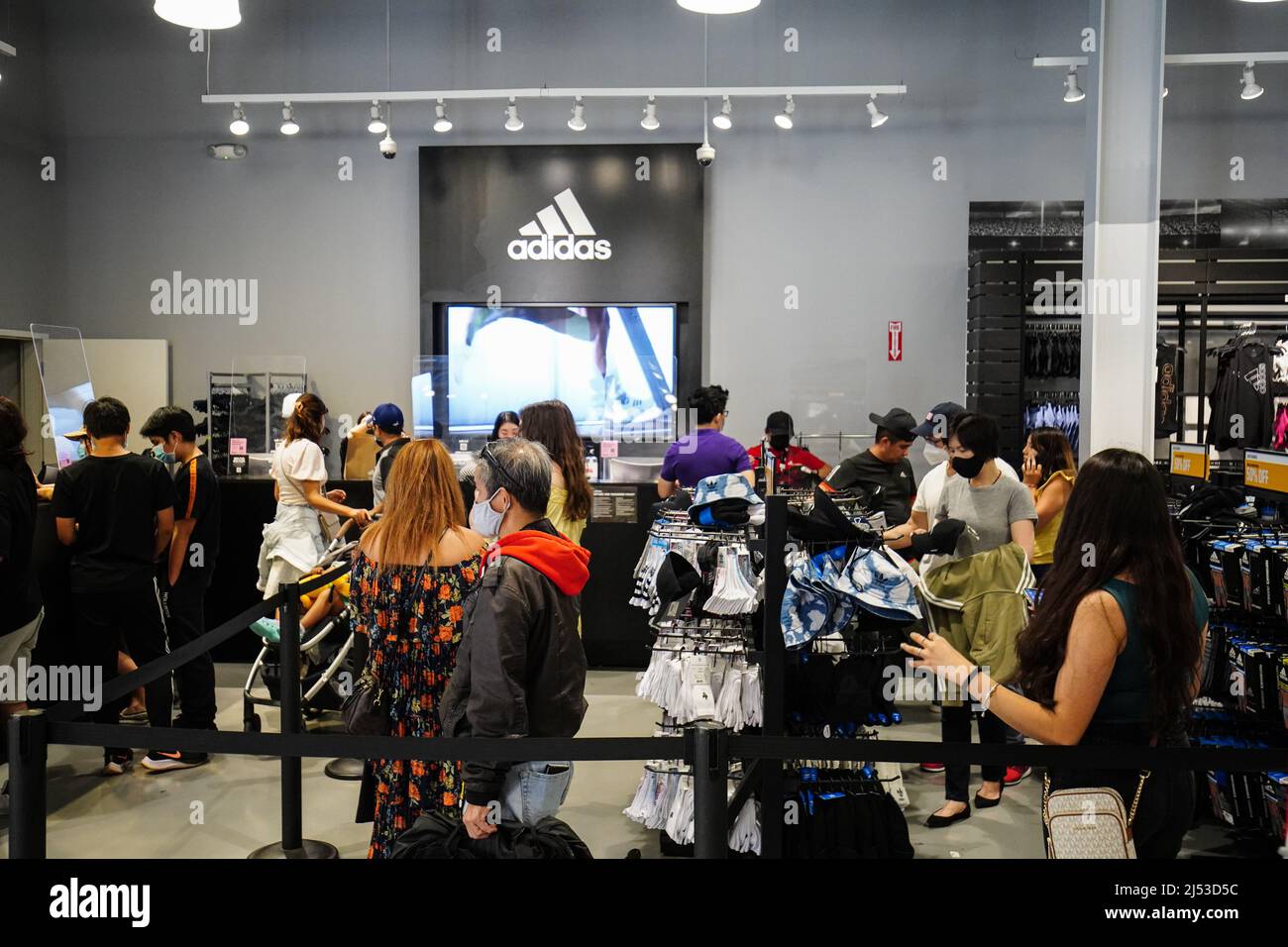 People seen shopping inside an Adidas store at The Outlets in Orange. Many  people shop at The Outlets in Orange, for clothes, shoes, watches, bags,  and backpacks with a discounted price. According
