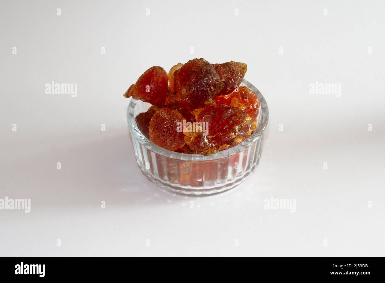 gum arabic  acacia senegal chunky pieces in glass bowl from top on white background Stock Photo