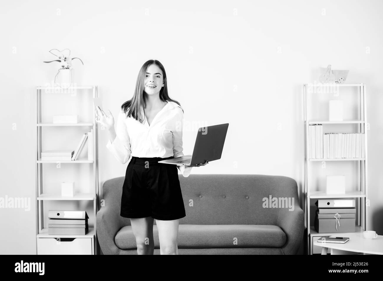 Young businesslady with laptop and credit card at workplace in the