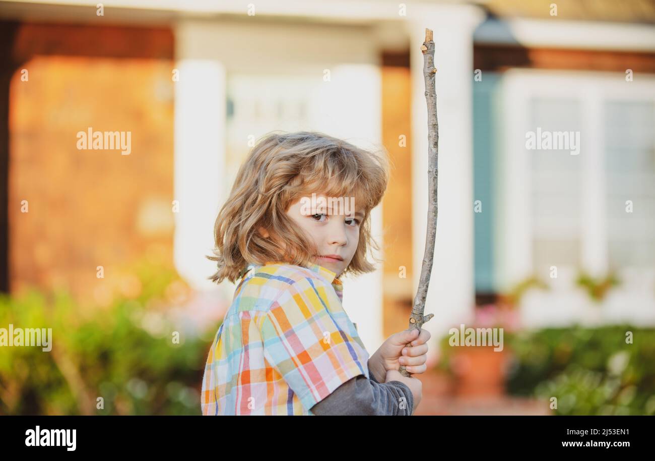 Child aggression concept. Negative kids emotion. Angry boy with stick