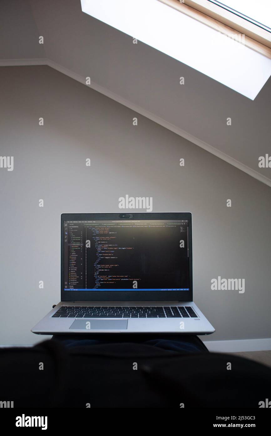 Opened laptop with code on the screen on the table Stock Photo