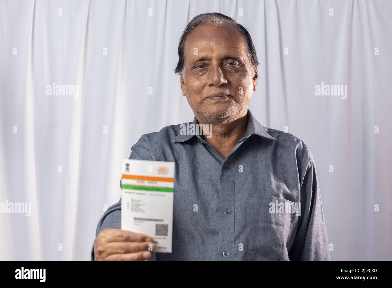 An Indian old man smiling with Aadhaar card in hands on white background  Stock Photo - Alamy