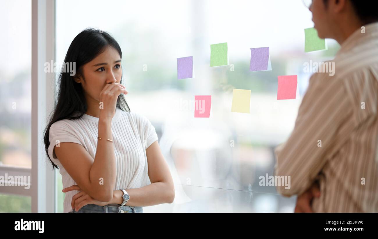 Female worker feeling upset and sad after she was complained the problems by her male boss in the office. Stock Photo