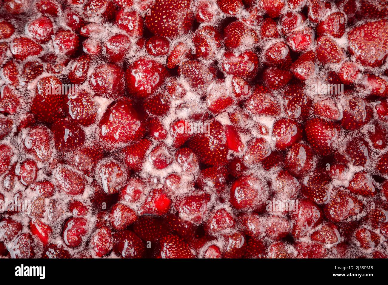 CLOSE UP: Strawberry jam. Make a strawberry jam. Boil strawberries in the pan. Process of cooking, boiling berries for canning. Healthy sweet food. Cooking strawberry jam close up. Stock Photo