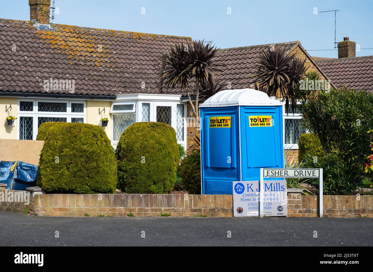 Porta Potty or Porta Potti, a portable toilet or loo outside a house undergoing construction for workers to use the toilet, in England, UK. Stock Photo