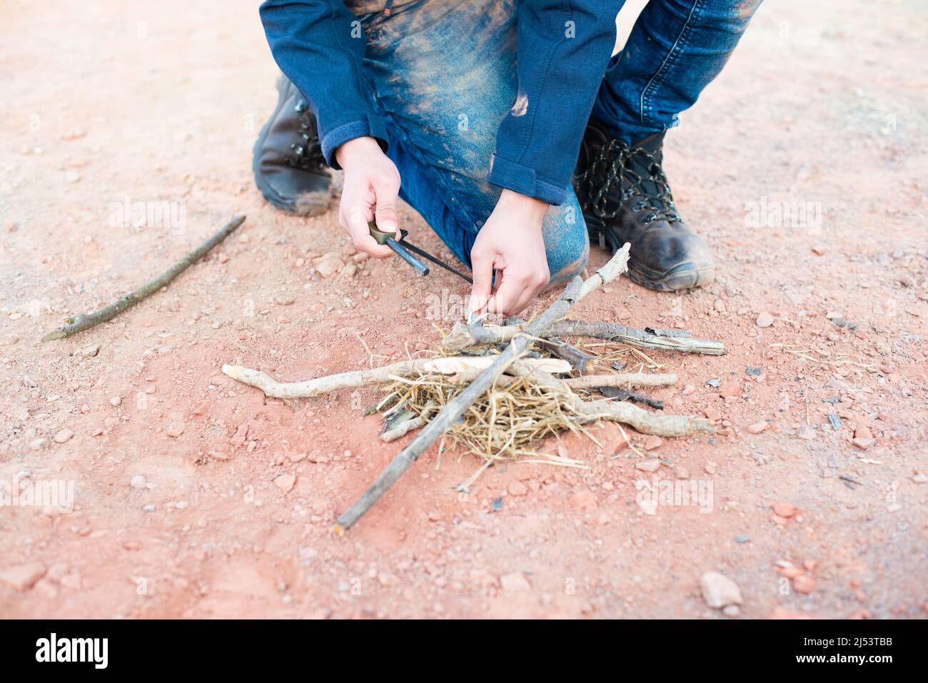 Starting a fire with a firesteel, survival and adventure equipment, outdoor skill, man making a campfire Stock Photo