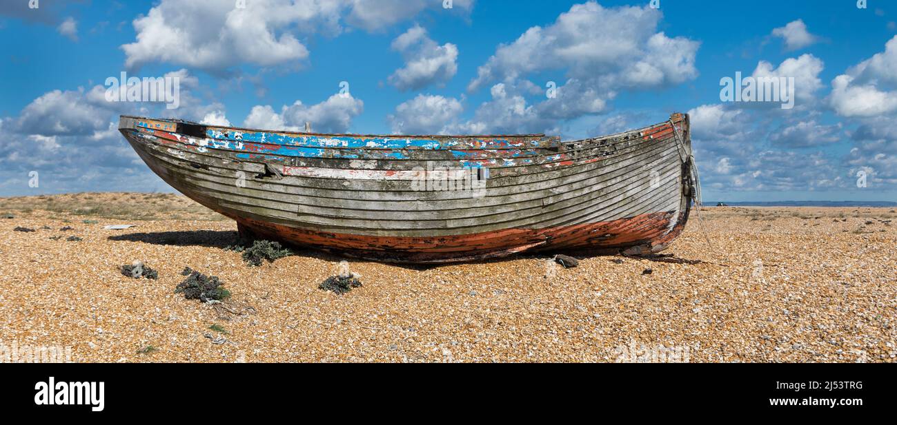 An old derelict abandoned wooden fishing boat on a shingle beach Stock ...
