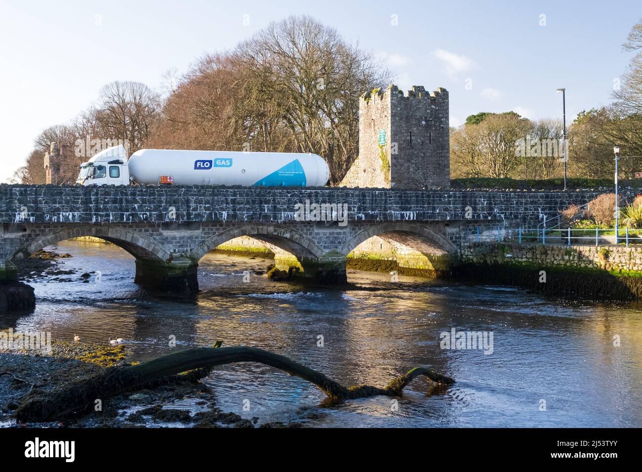 White Flo Gas truck drives across the bridge over the river at the entrance to the historic County Antrim village of Glenarm in Northern Ireland. Stock Photo