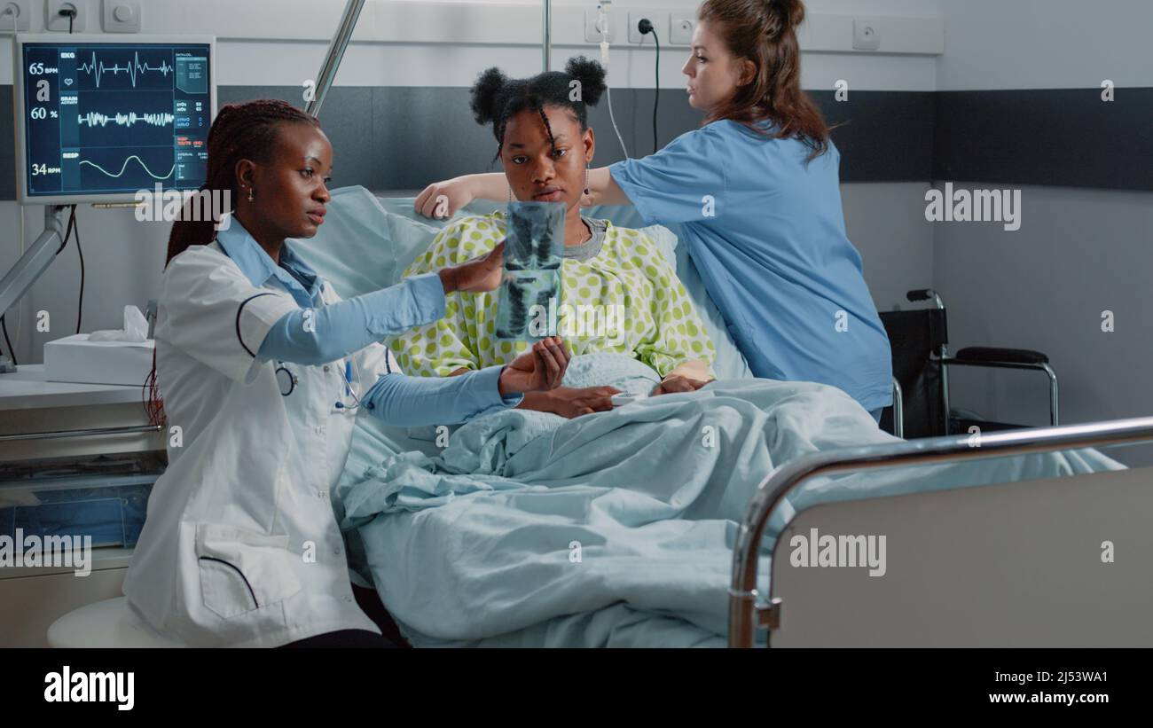 Physician showing radiography results to ill woman in bed. Medical ...