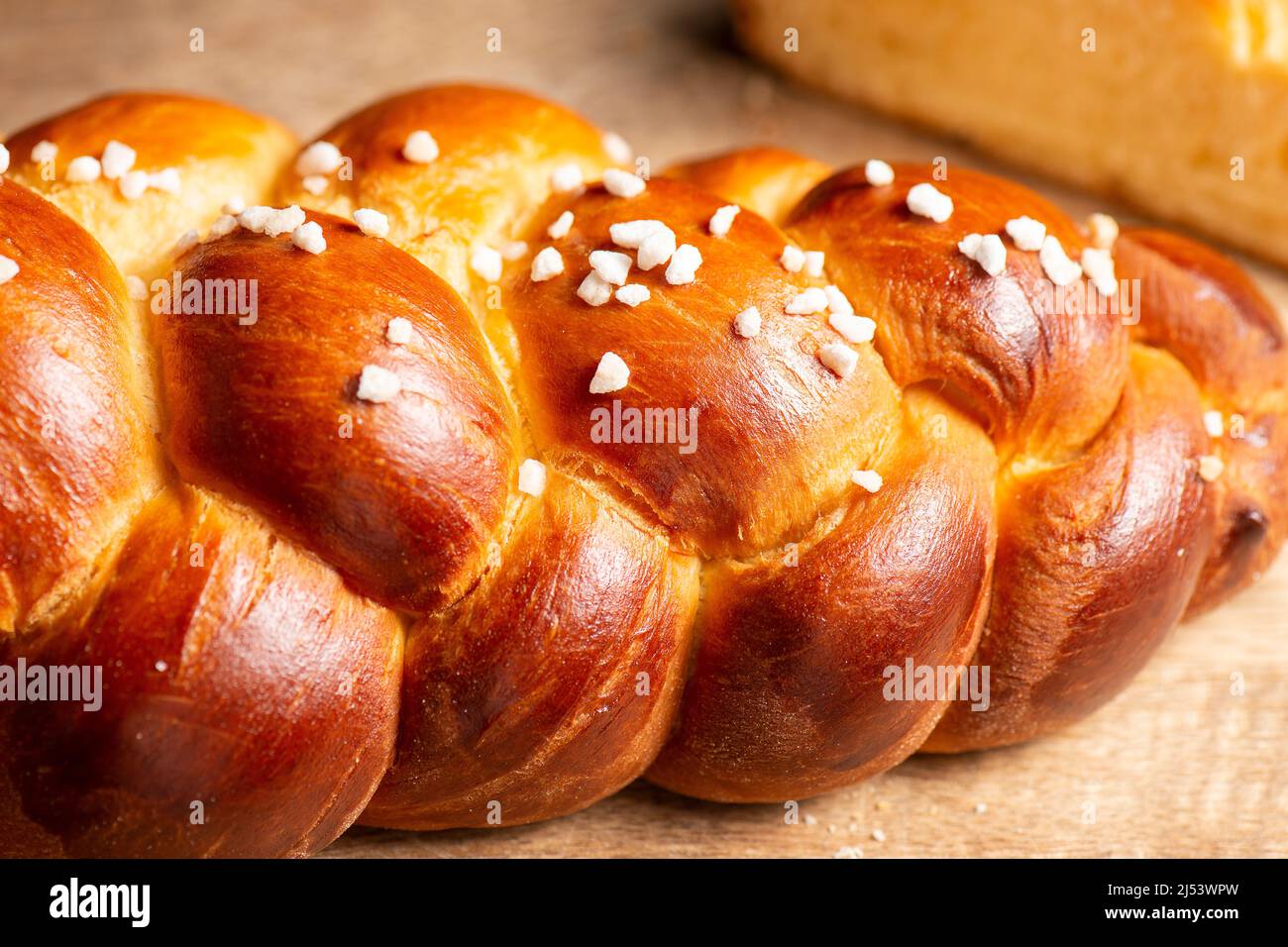 Beautiful three braid golden baked bread with egg wash and hail sugar