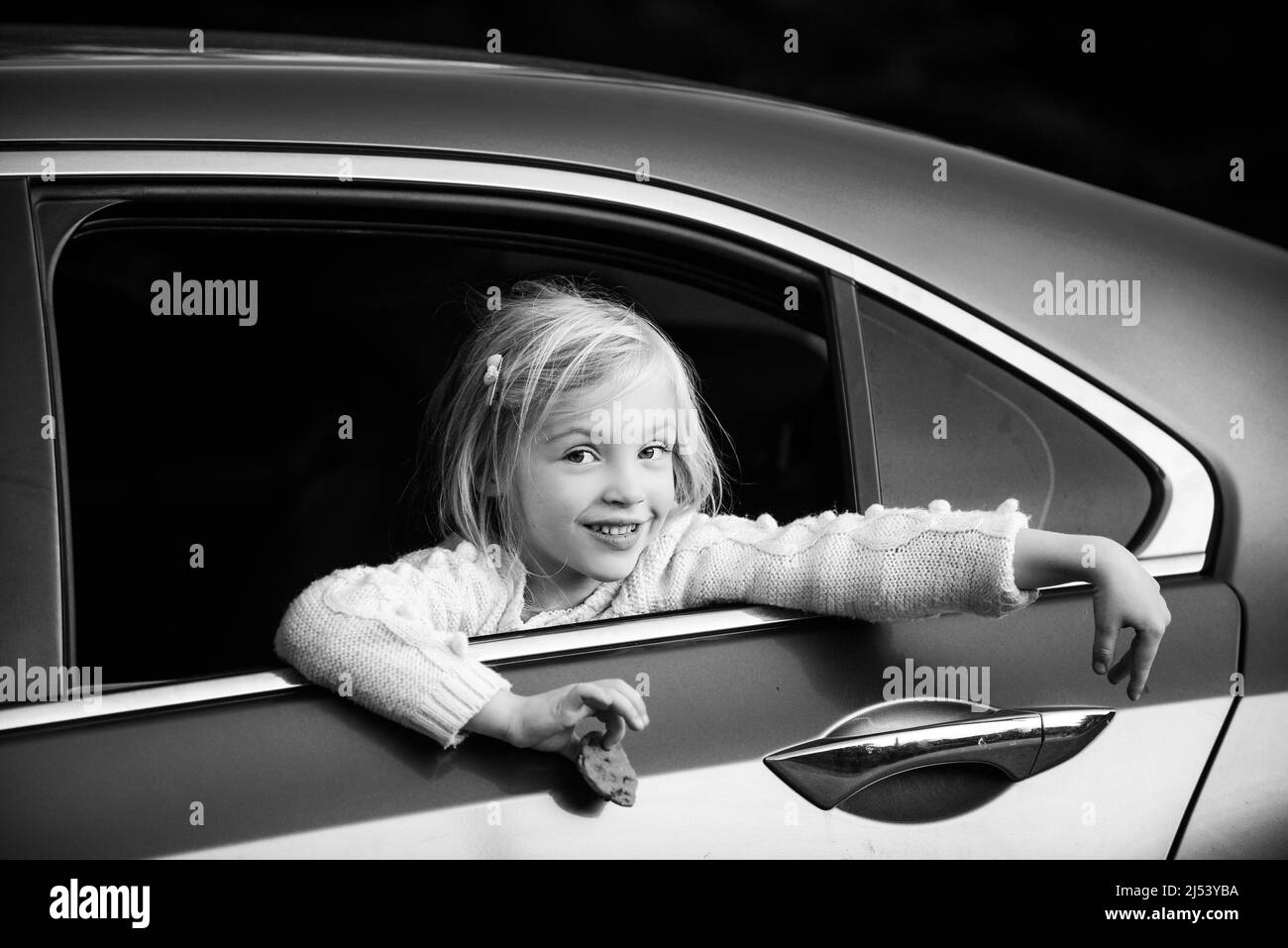 Little girl looking through car window Black and White Stock Photos ...